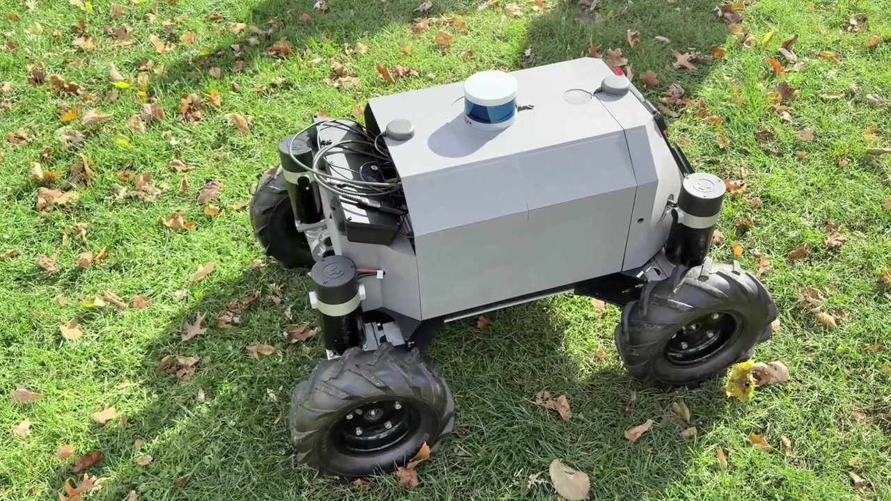 The electric off-road UGV on grass, with its LiDAR and stereo camera mounted on the body